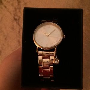 Claire’s gold watch with diamond charm.